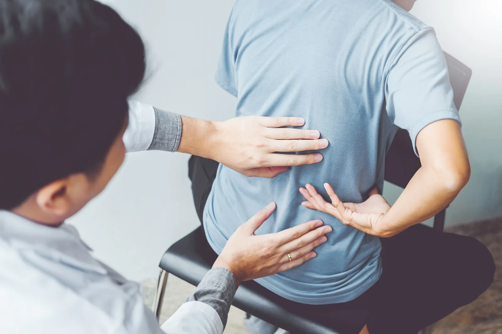 Chiropractor assessing a patient’s back